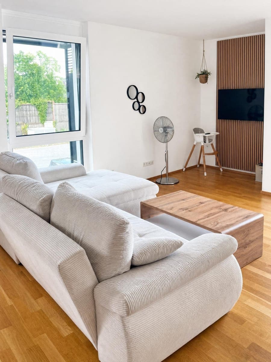 The same living room after optimisation: the view outside is held, colours are neutral and the lines are upright