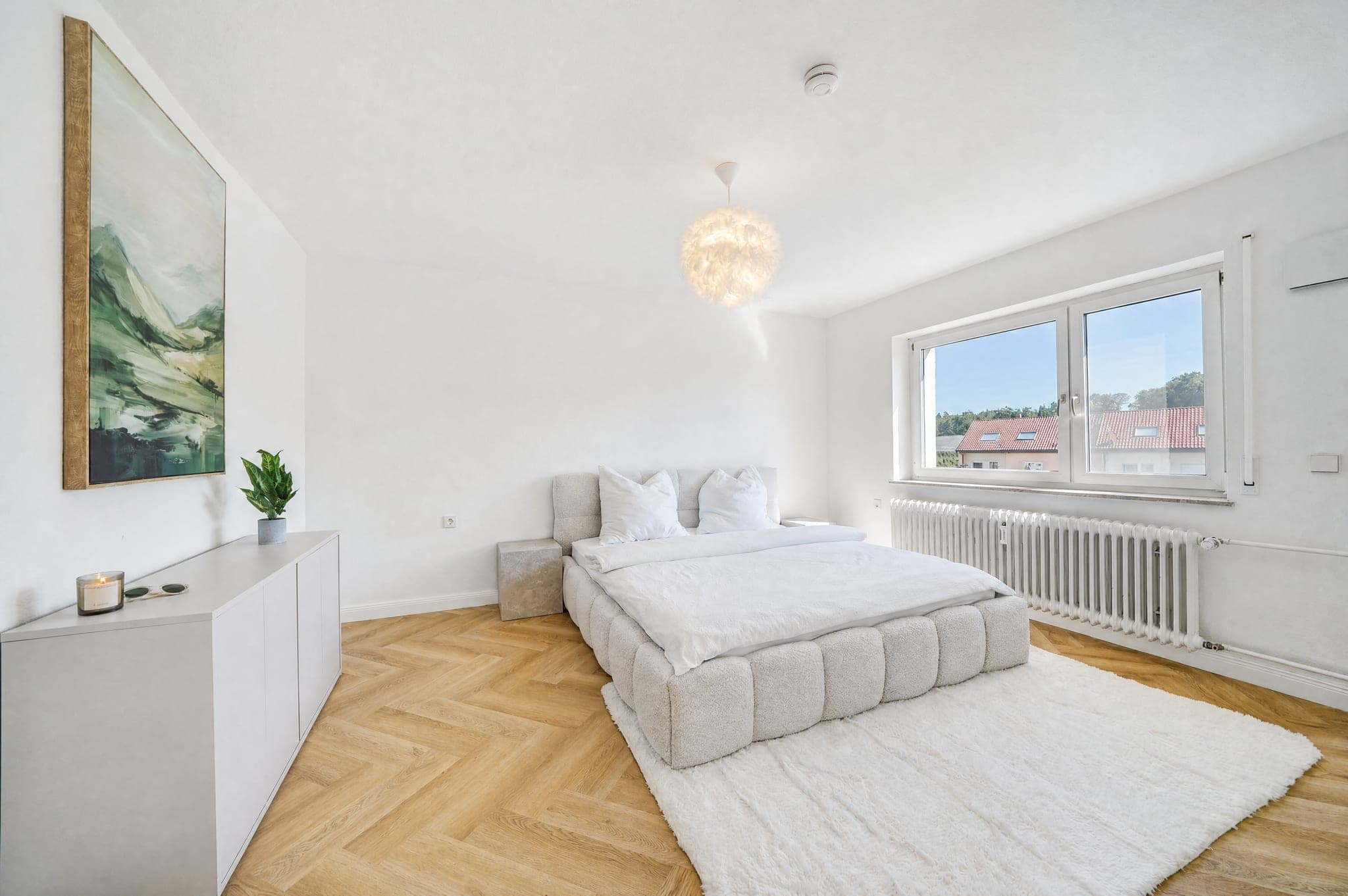 Bedroom with an upholstered bed under the slope; the window stays detailed despite the daylight