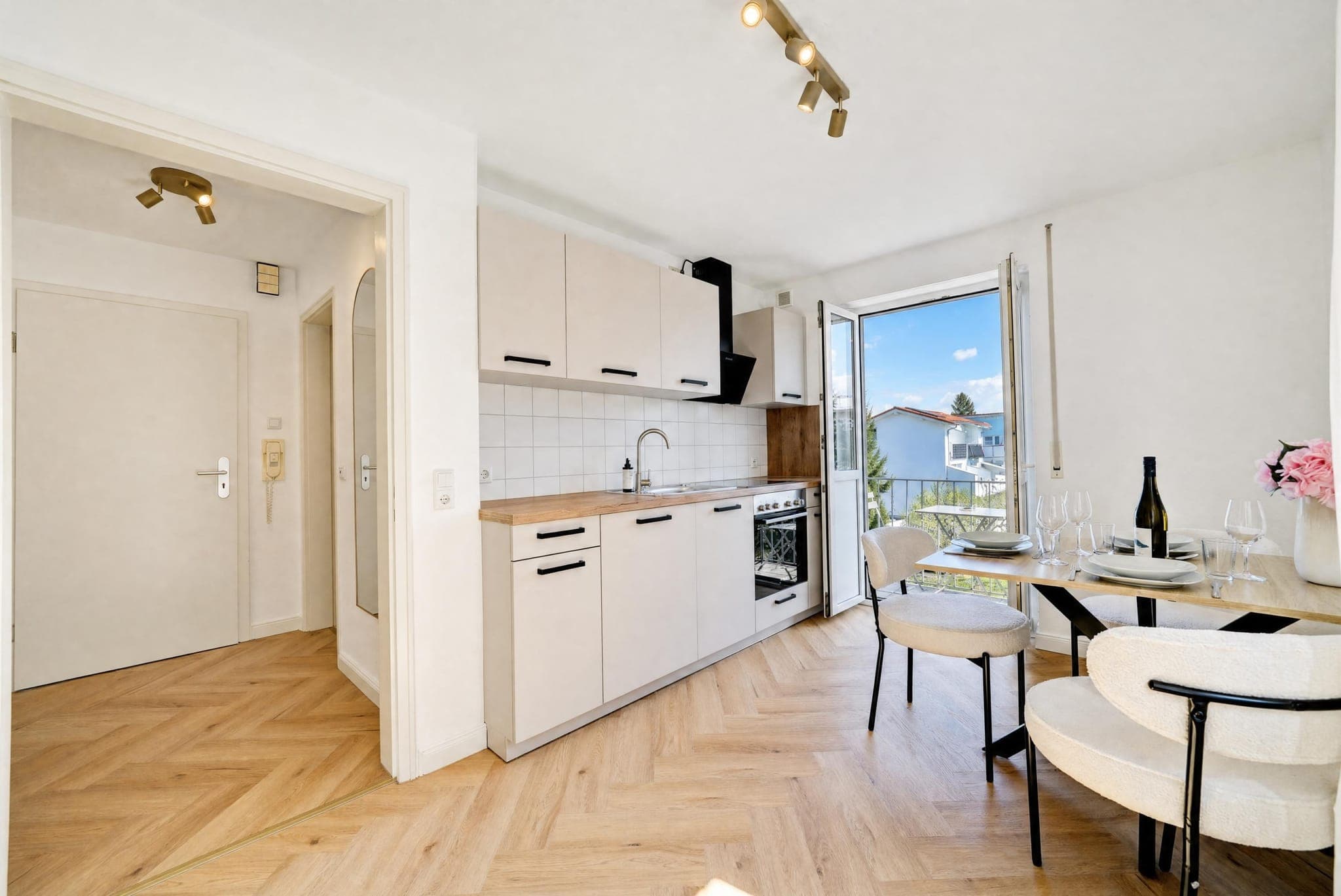 Run of kitchen units with a laid dining table at the balcony window