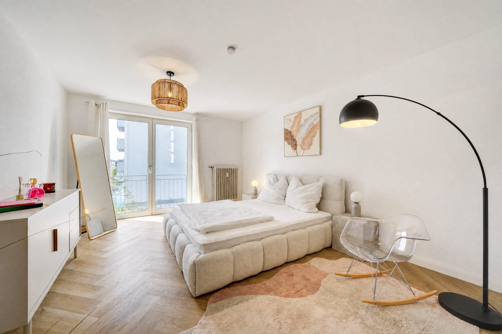 Bedroom with an upholstered bed, floor mirror and balcony door; the backlight at the window stays detailed