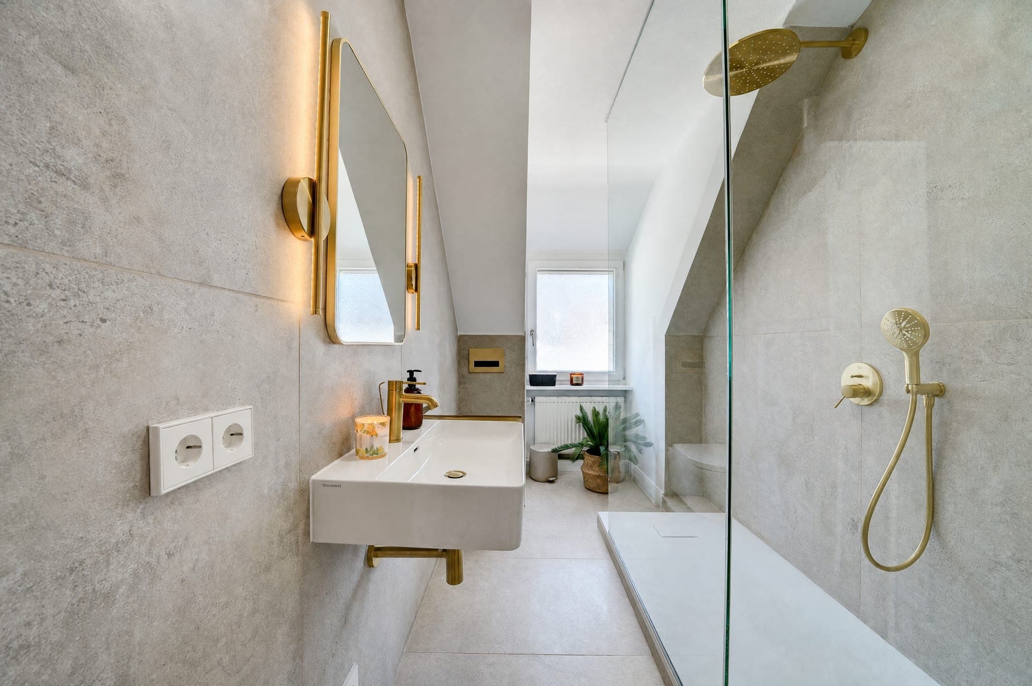 Bathroom with a walk-in shower, brass fittings and a countertop basin under the sloped ceiling
